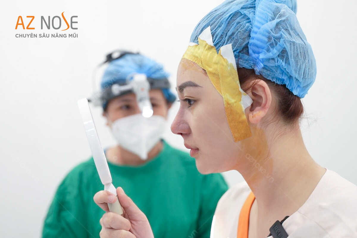 Bác sĩ chuyên môn Hoàng Thị Cẩm Nhung và khách hàng đang xem dáng mũi trước khi đóng vết khâu.